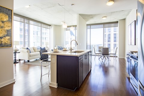 a kitchen with an island and a living room with a table and chairs